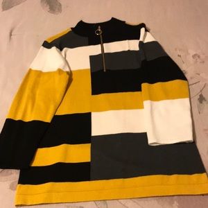 A medium sized sweater with a gray, black, and yellow design